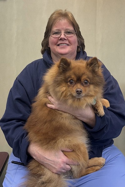 female with glasses holding a Pomeranian